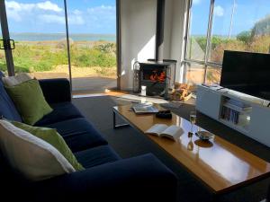 a living room with a couch and a fireplace at Coorong Waterfront Retreat in Meningie