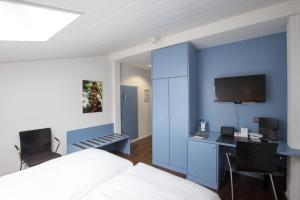 een slaapkamer met een bed, een bureau en een televisie bij Best Western Hotel Spirgarten in Zürich