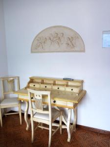 a wooden desk with a chair next to a wall at Hotel Villa Margherita in Limone sul Garda