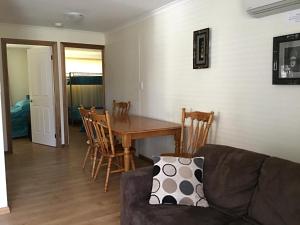 a living room with a couch and a table and chairs at Millicent Lakeside Caravan Park in Millicent