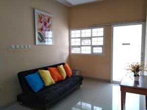 a black couch with colorful pillows in a living room at de' GREEN Cibubur in Cibubur