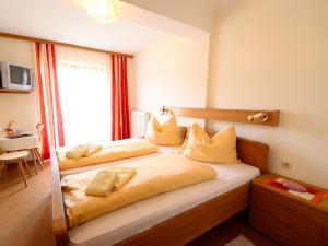 ein Hotelzimmer mit 2 Betten und einem Fenster in der Unterkunft Erlebnisbauernhof Urak in Sankt Kanzian am Klopeiner See