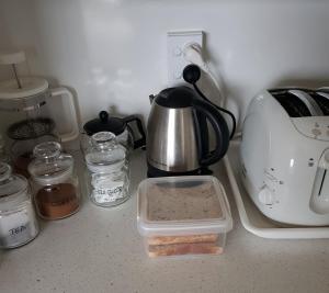 encimera de cocina con cafetera y otros artículos de cocina en Botanical Haven BnB, en Tauranga
