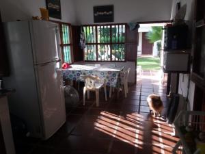 a kitchen with a table and a dog standing in the sun at Cabaña Coveñas Punta Bolivar in Coveñas
