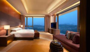 a hotel room with a bed and a large window at Hyatt Regency Guiyang in Guiyang