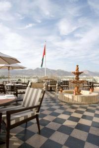 a patio with a fountain and tables and chairs at Grand Hyatt Muscat in Muscat