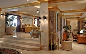 a lobby with a staircase and a living room at Grand Hyatt Muscat in Muscat