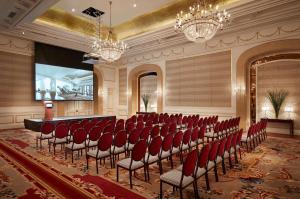 a conference room with red chairs and a stage at Park Hyatt Saigon in Ho Chi Minh City +86 photos