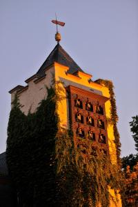 einen Uhrturm mit einem Kreuz darüber in der Unterkunft Breuer's Rüdesheimer Schloss in Rüdesheim am Rhein