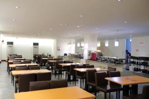 jadalnia ze stołami i krzesłami oraz kuchnia w obiekcie Dung Shin Hotel w mieście Taidong