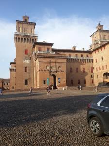 ein Gebäude mit einem davor geparkt in der Unterkunft Adelphi Room & Breakfast in Ferrara