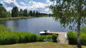 a boat parked on a dock on a lake at Skudras in Daugmale