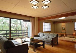 Sala de estar con 2 sofás y mesa en Hotel Laforet Shuzenji, en Izu