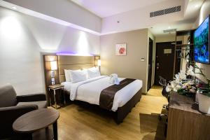 een hotelkamer met een groot bed en een televisie bij Bigland Hotel & Convention Sentul in Bogor