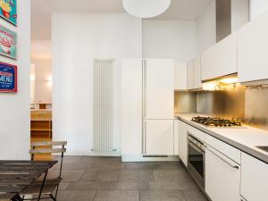 een keuken met witte kasten en een fornuis met oven bij easyhomes - Piola Bazzini in Milaan