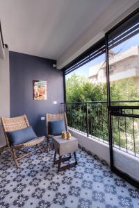 een kamer met een balkon met 2 stoelen en een tafel bij Yohanan HaSandlar in Tel Aviv