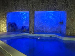 a swimming pool with blue lights in a room at Giardini Di Capodimonte Apartment in Naples