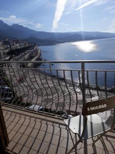 een bank op een balkon met uitzicht op een waterlichaam bij Il MOLO Camere per vacanze in Diamante