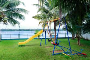 een speeltuin met een glijbaan op het gras bij Blue Waters Cherai in Cherai Beach