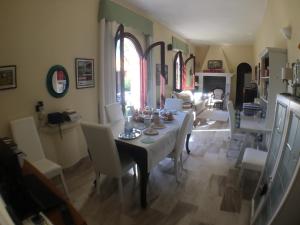 a dining room with a table and white chairs at Corte Arrubia in Monastir