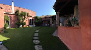 un cortile con erba verde accanto a un edificio di Corte Arrubia a Monastir