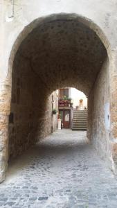 eine Gasse mit einem Torbogen in einem Steingebäude in der Unterkunft Casa Maria e Casa Cristina in Orvieto