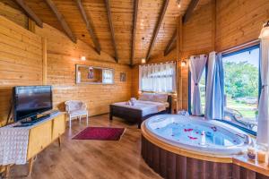 a jacuzzi tub in a room with wooden walls at Nof Tzameret Cabins in Kahal