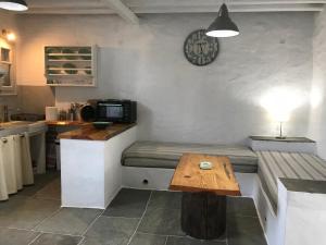 a kitchen with a bench and a clock on the wall at Windmill Arades suite in Apollonia +31 photos