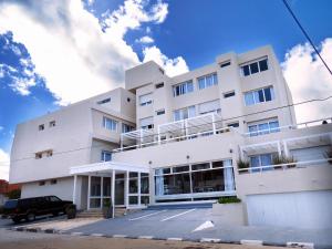 a white building with a car parked in front of it at Atlántico Boutique Hotel in Punta del Este