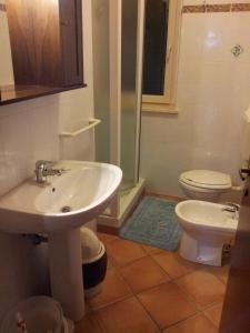 a bathroom with a sink and a toilet and a shower at Agriturismo Casa degli Archi in Lapedona