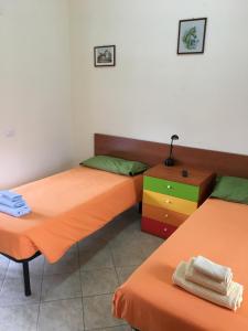 Zimmer mit 2 Einzelbetten und einer Kommode in der Unterkunft Boscotenso in Premosello Chiovenda