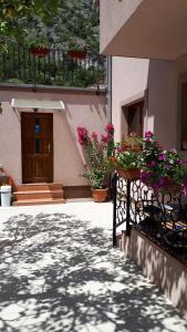 ein Gebäude mit Blumen auf einem Zaun und einer Tür in der Unterkunft Hostel Bojo in Mostar