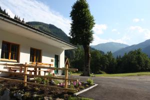 una casa con panchina e vista sulle montagne di Chalet Ferienhaus Radmer a Radmer an der Hasel