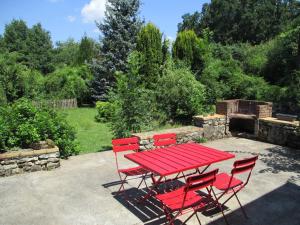 a red picnic table and chairs in a garden at "Le Jardin de Zola", Longère XIXème en BOURGOGNE, grand jardin in Lurcy-le-Bourg +20 photos