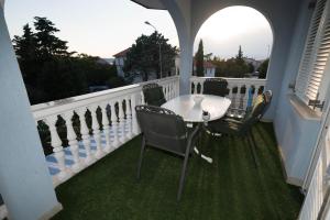 a porch with a table and chairs on a balcony at Villa Blue in Selce