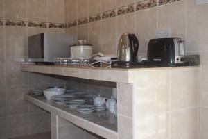 a kitchen with a counter with plates and a coffee maker at Pension Citadelle in La Digue