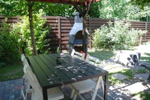 Nóra Apartman في غيولا: طاولة خضراء وكراسي مع منزل للطيور