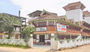 un gran edificio con una torre encima en KTDC Tamarind Easy Hotel en Guruvāyūr