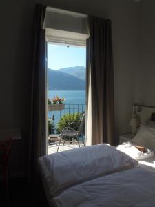 a bedroom with a window with a view of the ocean at Albergo Dongo in Dongo