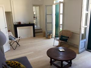 a living room with a coffee table and chairs at Le cœur d'Orques in Saint-Georges-dʼOrques