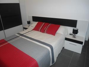 a bedroom with a bed with a red and white blanket at casa Mariona in Riumar +35 photos