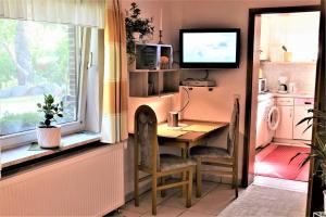 eine Küche mit einem Tisch, einem Fenster und einem TV in der Unterkunft Ferienhaus Reher in Krummsee