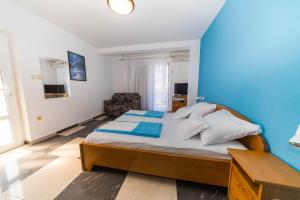 a bedroom with a large bed and a blue wall at Villa Blue in Selce