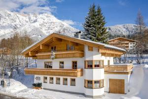 ein Haus im Schnee vor einem Berg in der Unterkunft Haus Christoph in Maria Alm am Steinernen Meer