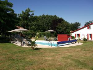 a pool with a slide and chairs and a house at Gîte La Forge De Clermont in Clermont