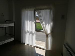 A bed or beds in a room at Albergue O Trisquel