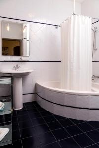 uma casa de banho com uma banheira, um lavatório e uma cortina de chuveiro em Quinta do Covanco em Alenquer