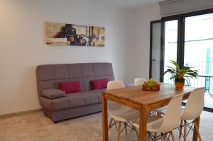 sala de estar con mesa y sofá en Arkadia Apartaments 2.2, en Roses