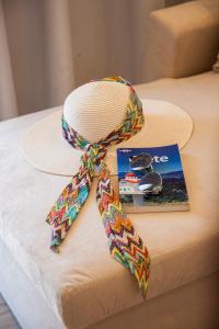 a hat and a ribbon on a bed with a magazine at Afroditi in Rethymno Town