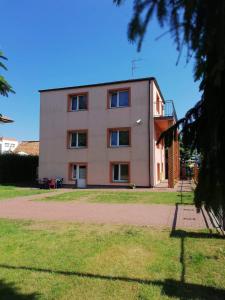 a building with a grassy yard in front of it at Dom Wczasowy Mateusz in Rewal